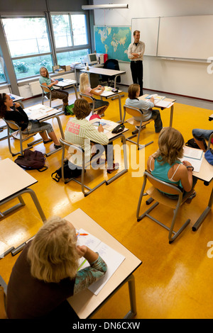 Teacher in schoolclass is talking to girl students Stock Photo
