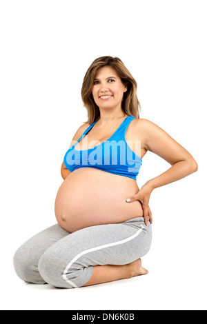 Beautiful pregnant woman posing in fitness clothes Stock Photo