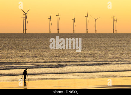 Man metal detecting with metal detector on beach. UK Stock Photo