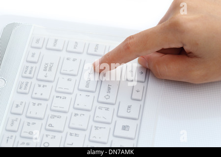 finger pushing the enter button of keyboard Stock Photo