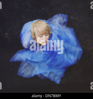 Woman with closed eyes wrapped in blue cloth Stock Photo
