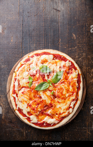 Pizza Margarita with basil leaves on wooden table Stock Photo