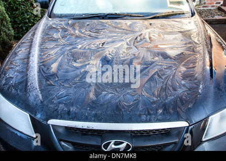 FROST AND ICE ON A CAR IN THE MORNING WITH EARLY MORNING SUN JUST REACHING IT Stock Photo
