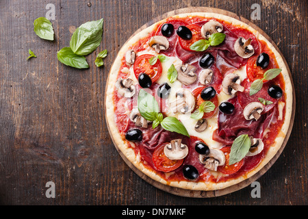 Italian pizza with salami, mushrooms and olives on wooden table Stock Photo