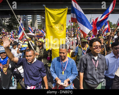 Bangkok, Thailand. 20th Dec, 2013. Anti-government protestors march down Silom Road. Thousands of anti-government protestors, supporters of the so called Peoples Democratic Reform Committee (PRDC), jammed the Silom area, the ''Wall Street'' of Bangkok, Friday as a part of the ongoing protests against the caretaker government of Yingluck Shinawatra. Yingluck dissolved the Thai Parliament earlier this month and called for national elections on Feb. 2, 2014. Credit:  ZUMA Press, Inc./Alamy Live News Stock Photo