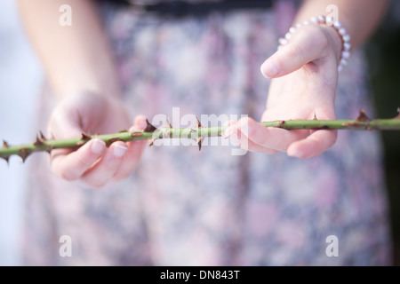 Young woman in snow with thorn branch in the hand Stock Photo