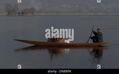 Srinagar, Indian Administered Kashmir 20 December2013  A man rows his boat on Dal lake in Srinagar, the summer capital of Indian-administered Kashmir . Kashmir has been called a 'paradise on Earth,' for centuries capturing the imagination of writers, poets, filmmakers and tourists, as the tourism industry has been growing in recent years. Kashmir has been a contested land between nuclear neighbors India and Pakistan since 1947, the year both the countries attained freedom from British rule. (Sofi Suhail/ Alamy Live News) Stock Photo