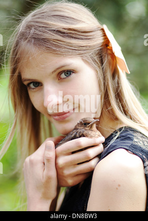 Girl with young bird on shoulder Stock Photo