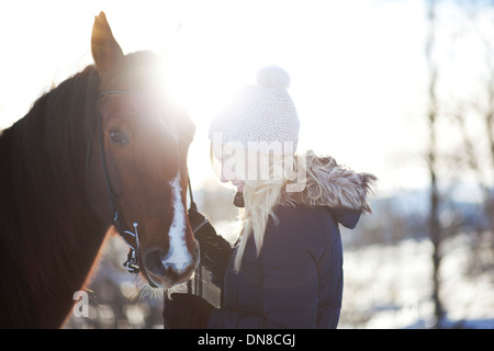 Young woman with horse in winter Stock Photo