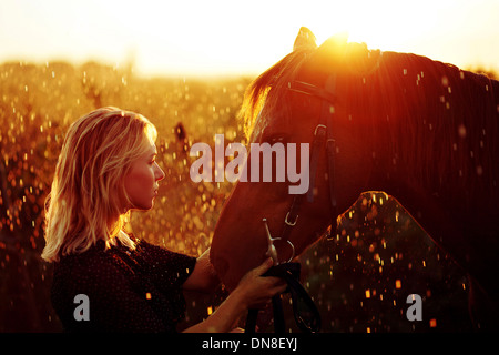 Woman with horse at sunset Stock Photo