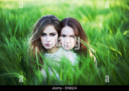 Two women sitting in the cornfield Stock Photo