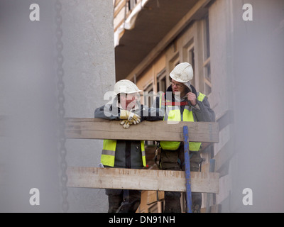 two men chatting on a building construction site in Breda, the Netherlands Stock Photo