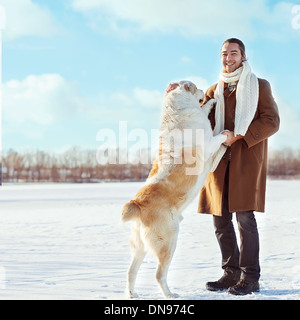 Man and central Asian shepherd walk in the lake Stock Photo