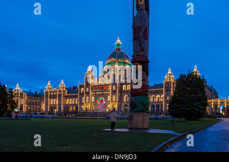 British Columbia Legislative buildings lit up for Christmas at dusk with totem pole-Victoria, British Columbia, Canada. Stock Photo