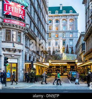 The Savoy luxury hotel entrance and Christmas trees at Xmas - 'Let it be' showing at the theatre - The Strand, London Stock Photo