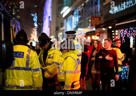 Manchester, UK. 20th December, 2013. Police and other emergency services are out in the streets on the night dubbed 'Mad Friday' - the last Friday before Christmas. The day is traditionally a night when many company employees enjoy each other's company with the aid of alcohol, though has become notorious for people going 'too far' when people can often end up ill or injured. Credit:  Russell Hart/Alamy Live News Stock Photo