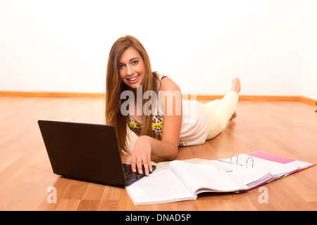 Beautiful teenager who wears braces, studying in her living room Stock Photo