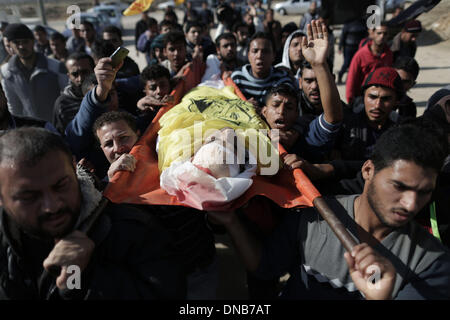 Gaza, Palestine, Middle East. 21st Dec, 2013. Palestinian carry the body of 22-year-old Odah Hamad during his funeral in northern Gaza Strip town of Beit Hanoun, on Dec. 21, 2013. Israeli forces shot dead a Palestinian man in northeast Gaza near the border, medical sources and witnesses said Friday. The witnesses said that the Israeli troops stationed at the border to the east of Beit Hanoun town opened fire at Ouda Hamad, 22, and killed him when he approached the security fence. Credit:  Wissam Nassar/Xinhua/Alamy Live News Stock Photo