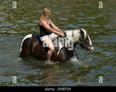 Gypsy traveller girl riding horse in River Eden. Appleby Horse Fair, June 2013. Appleby-in-Westmorland, Cumbria, England. Stock Photo