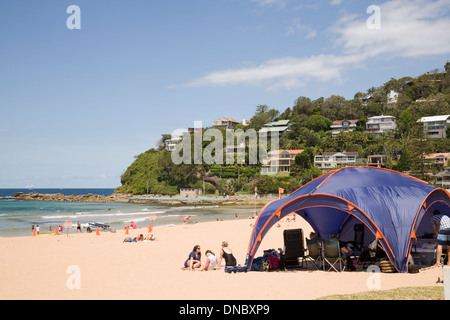 People under a shade tent at Palm beach,Sydney.Australia Stock Photo
