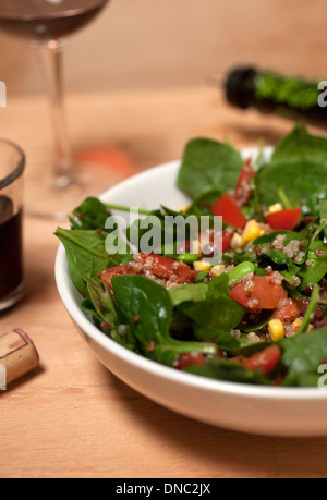 spinach salad in white bowl on wood table Stock Photo