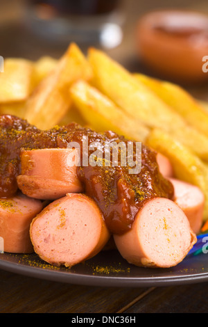 German fast food called Currywurst served with French fries on a plate Stock Photo