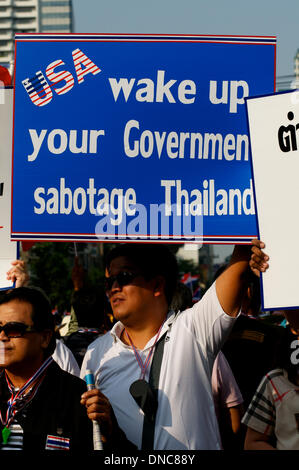 Bangkok, Thailand. 22nd Dec, 2013. Anti-government protesters hold signs blaming the USA for their problems. Tens of thousands of protesters took to the streets to demand the resignation of Thai Prime Minister Yingluck Shinawatra. Credit:  Kraig Lieb / Alamy Live News Stock Photo