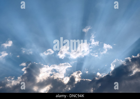 The Sun rays going through dark clouds Stock Photo