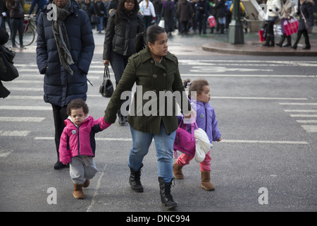Mother with young children crossing 34th Street in NYC. Stock Photo