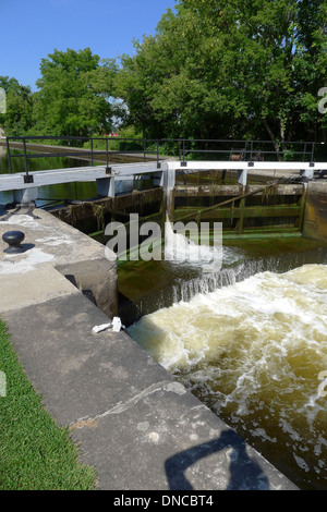 Water rushing through the manually operated lock gates as they are opened at Merrickville lock station, part of the historic Rideau canal system. Stock Photo
