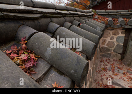 Giwa (fired clay roof tiles) used on  traditional Hanok style stone wall fence - Gyeongju, South Korea Stock Photo