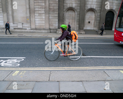 A woman cyclist  commuter in the cycling lane on Threadneedle Street in the City of London UK KATHY DEWITT Stock Photo
