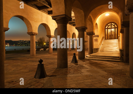 Evening view of the colonnade and Riddarfjärden beyond, from the piazza of Stockholm City Hall (Stockholms stadshus) (1911-1923) Stock Photo