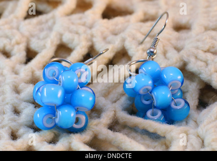 Handmade earrings made of blue beads on the knitted background Stock Photo