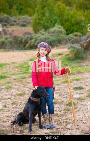 Kid girl shepherdess happy with dog flock of sheep and wooden stick in Spain Stock Photo