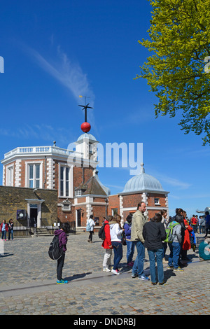Group of people stand at prime meridian Greenwich Observatory & red historical Time Ball above Flamstead House beyond Greenwich Park London England UK Stock Photo