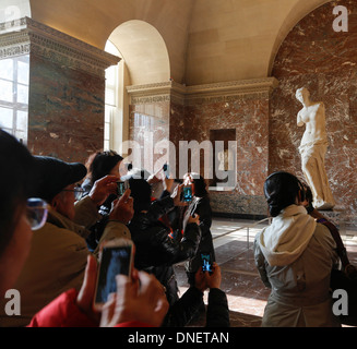 people taking photos in front of the Venus de Milo sculpture by Alexandros of Antioch, Louvre Museum, Paris, France Stock Photo