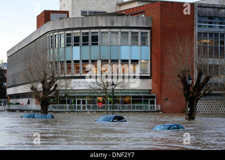 Guildford, Surrey, UK 24th December 2013. Rising flood water from the River Wey envelops cars in the Millmead Car Park with the Debenhams department store in the background. The flooding has been caused by heavy rainfall over the last 24 hours. Credit:  Bruce McGowan/Alamy Live News Stock Photo