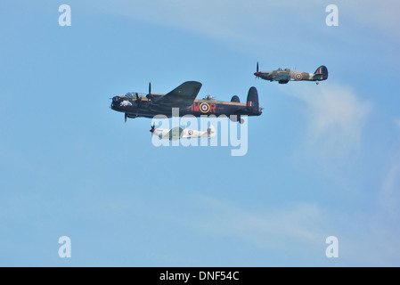 Formation of WWII Spitfire, Hurricane and Lancaster Bomber of BBMF - Battle of Britain Memorial Flight - in flight against blue Stock Photo