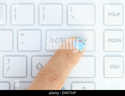close-up finger pushing the enter button of keyboard Stock Photo