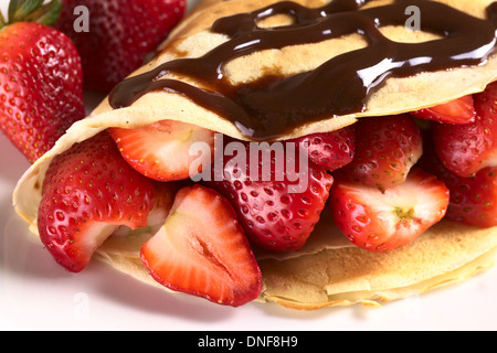 Crepe filled with fresh strawberries and chocolate sauce on top Stock Photo