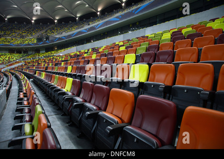 Rows of empty seats of different colors in a stadium Stock Photo