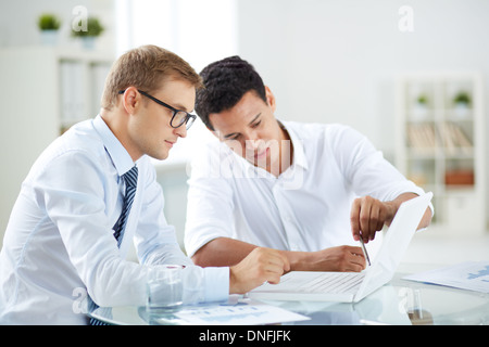 Portrait of smart businessmen discussing project in laptop at meeting Stock Photo