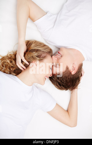 Two happy young dates with closed eyes lying in bed Stock Photo