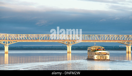 Tourist boat approaches the Pakokku Bridge across the Irrawaddy River in Myanmar. Myanmar travel and people images. Stock Photo