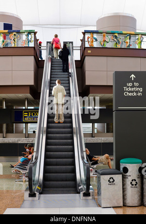 Travelers on escalator, Denver International Airport Stock Photo