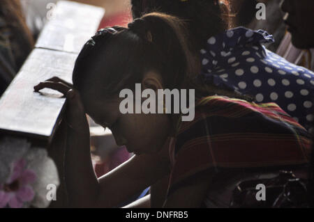 Agartala, Tripura, India. 25th Dec, 2013. A girl is praying in the church during the Christmas Mass in Agartala, capital of the North Eastern state of Tripura. Many Christians went to churches to pay their Christmas prayers across the country. Photo: Abhisek Saha/NurPhoto Credit:  Abhisek Saha/NurPhoto/ZUMAPRESS.com/Alamy Live News Stock Photo