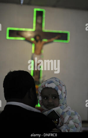 Agartala, Tripura, India. 25th Dec, 2013. A father with his baby offer prayers at the church during the Christmas Mass in Agartala, capital of the North Eastern state of Tripura. Many Christians went to churches to pay their Christmas prayers across the country. Photo: Abhisek Saha/NurPhoto Credit:  Abhisek Saha/NurPhoto/ZUMAPRESS.com/Alamy Live News Stock Photo