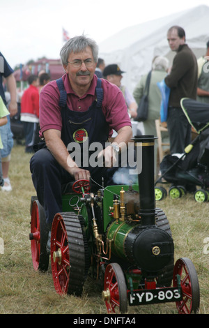 man riding a tiny vintage traction engine Stock Photo