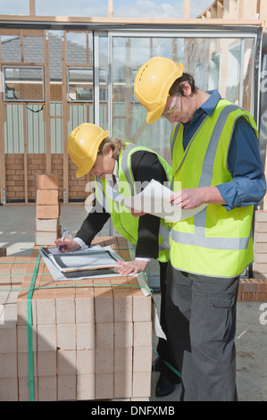 civil engineer and worker discussing issues at the construction site Stock Photo